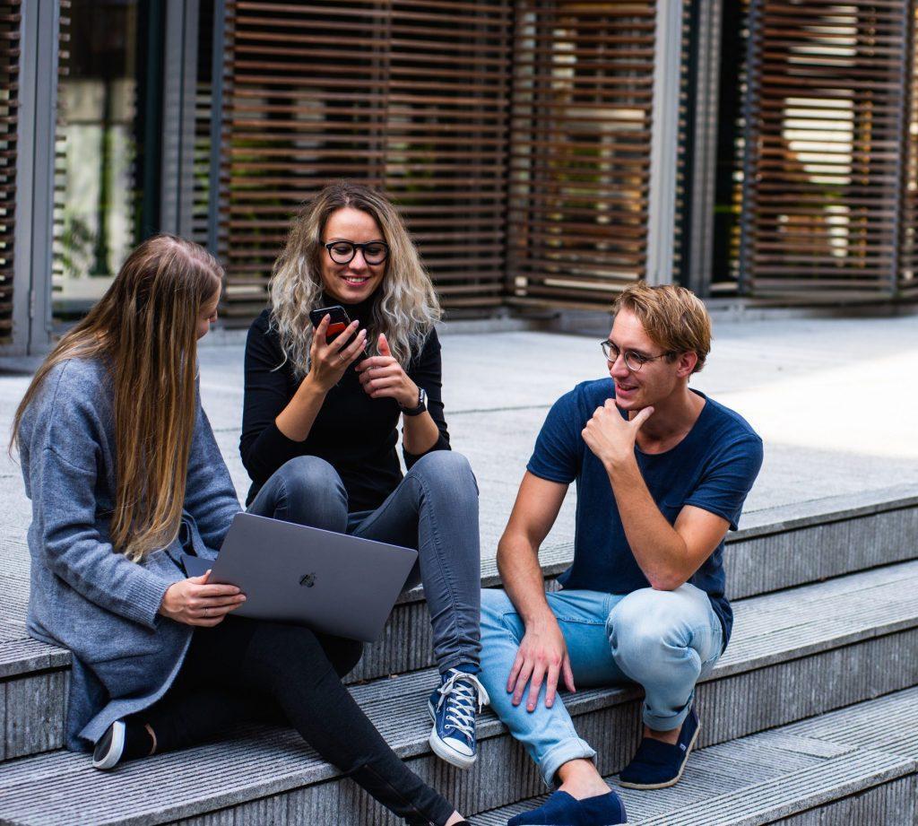 three-persons-sitting-on-the-stairs-talking-with-each-other-1438072